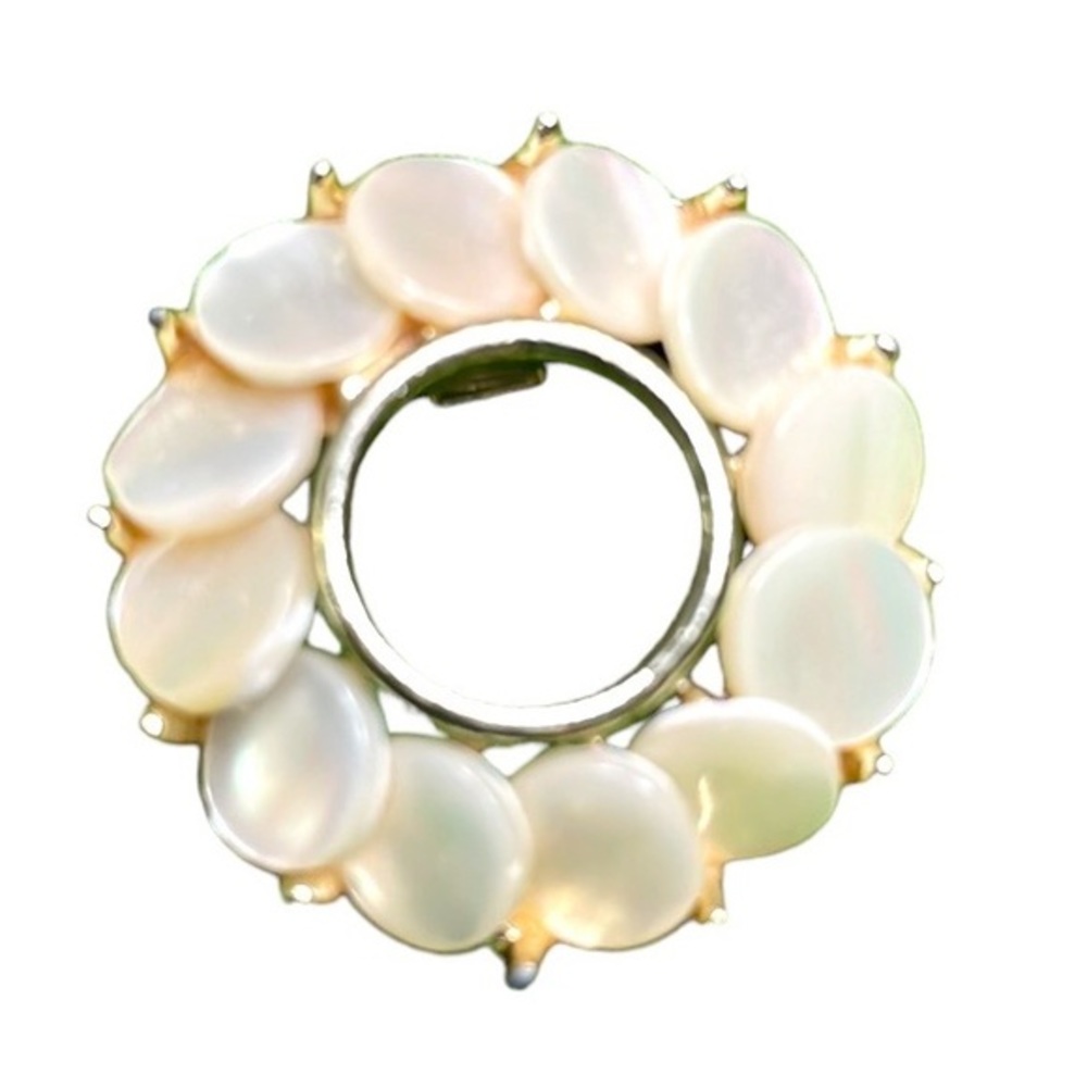 Vintage mother of pearl circle pin brooch set in‎ a gold toned pronged setting.